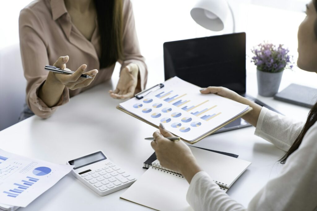 Teamwork process. Two business women calculating a valuation in the workplace. laptop on the table,