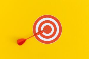 Dart on red target on a yellow background. Top view. Flat lay.
